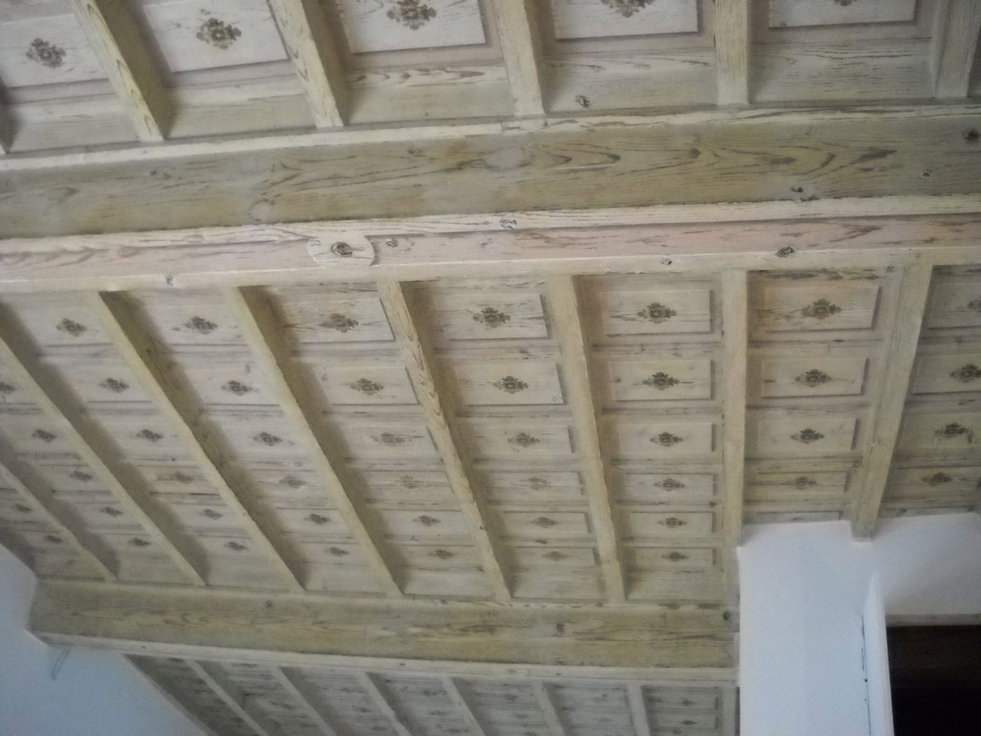 Soffitto a cassettoni in legno coperto da vecchie pitture, prima dell'intervento